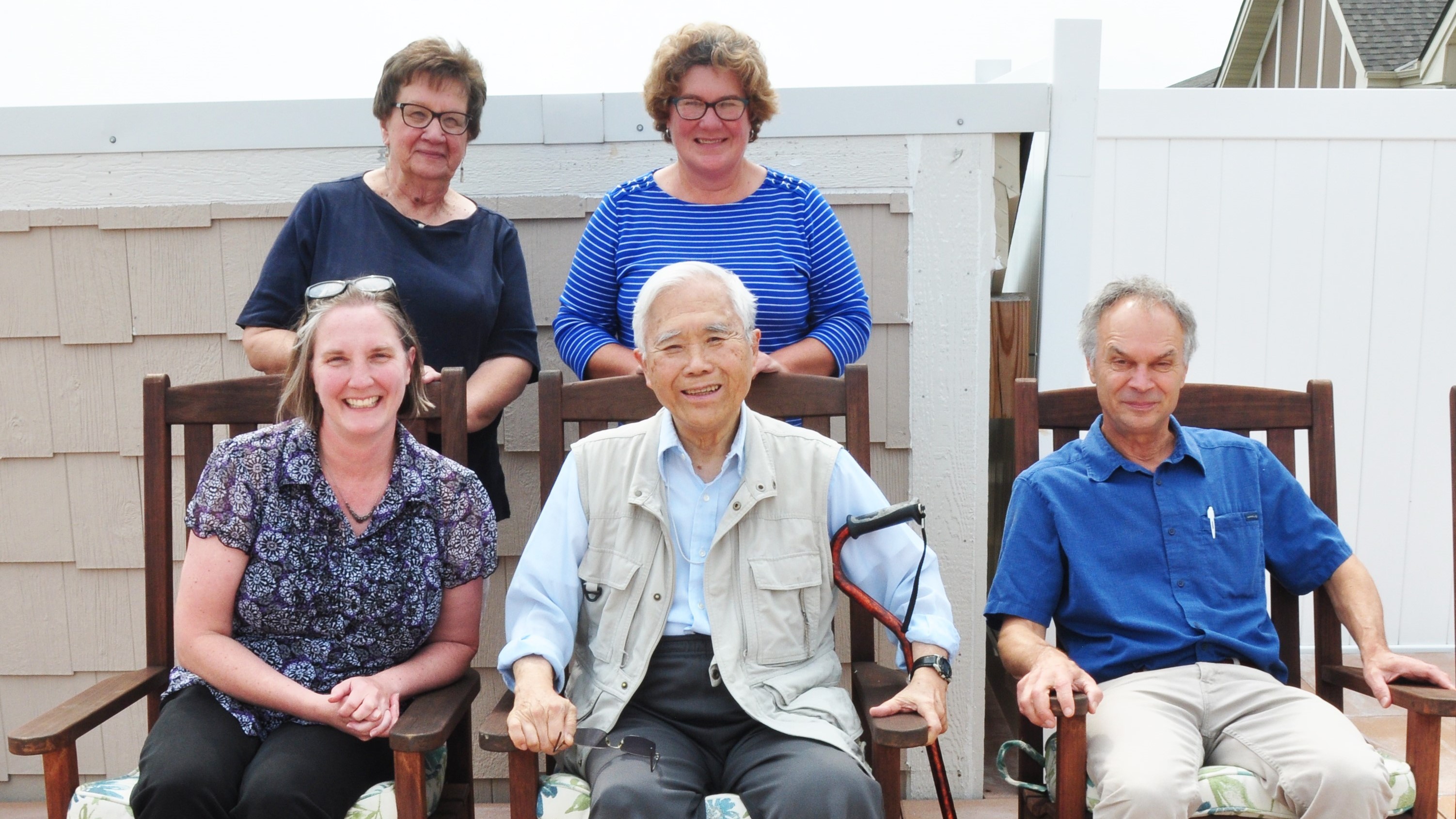 A photo of HH Cheng sitting in a rocking chair surrounded by friends and colleagues from the Department of Soil, Water, and Climate 