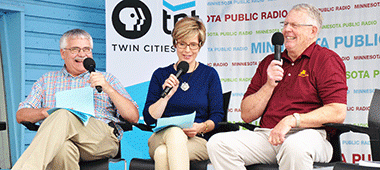A photo of three people sitting and speaking into microphones; the PBS Twin Cities logo is in the background