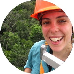 woman smiling in hardhat above trees
