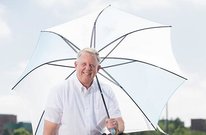 Mark Seeley holding a large white umbrella