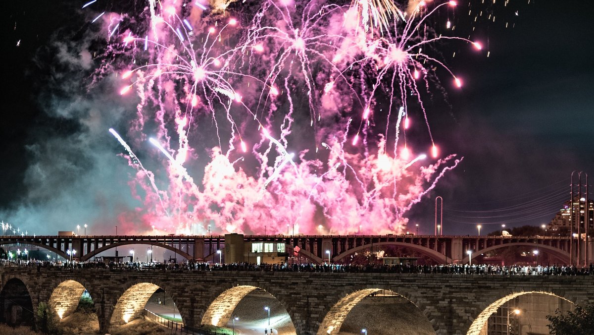 A photo of fireworks over the Stone Arch Bridge and the Mississippi River in Minneapolis