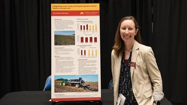 A photo of Melissa Wilson standing next to a scientific poster