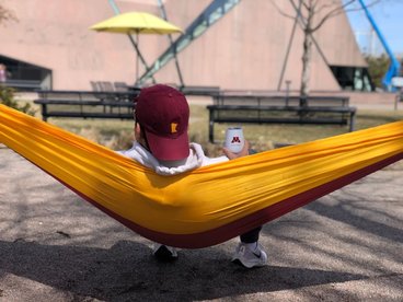 A photo of a student in a maroon and gold hammock