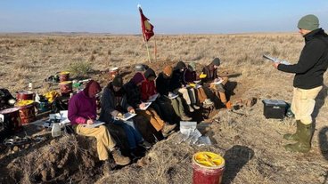 A photo of the UMN Soil Judging Team learning from their coach Nic Jelinski in the field