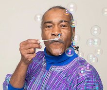 A photo of the speaker Melvin Giles, blowing bubbles